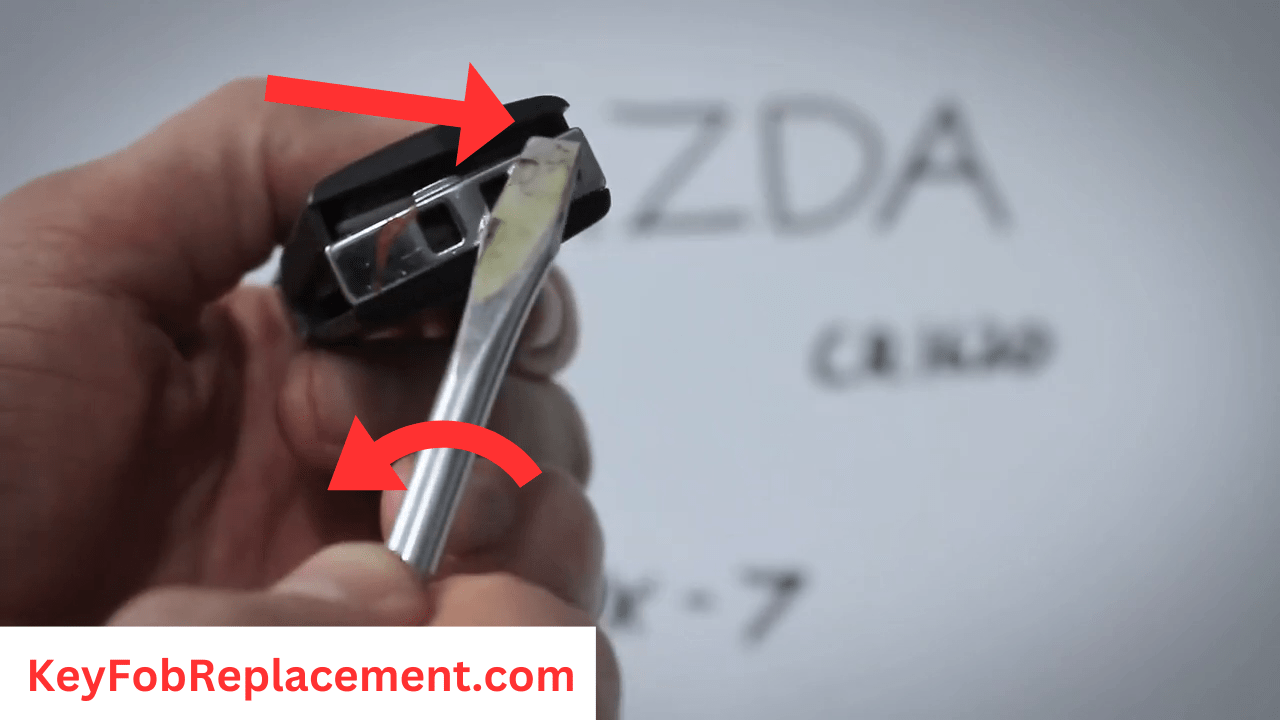 Mazda CX-7 Flip Key Use screwdriver to separate key fob, reveal battery