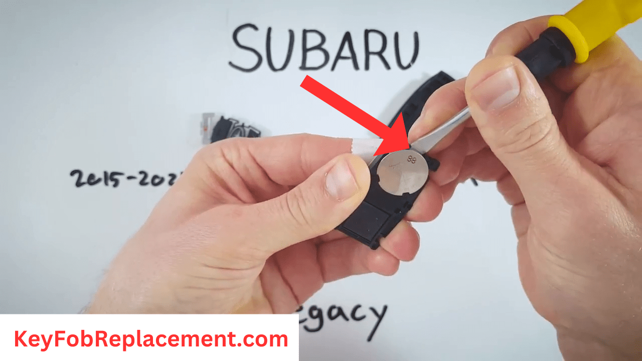 Subaru Legacy Insert screwdriver in battery's space, pop it out
